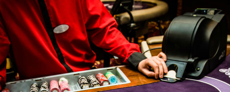Blackjack Händler mit Kasino Chips und Kartenmischmaschine